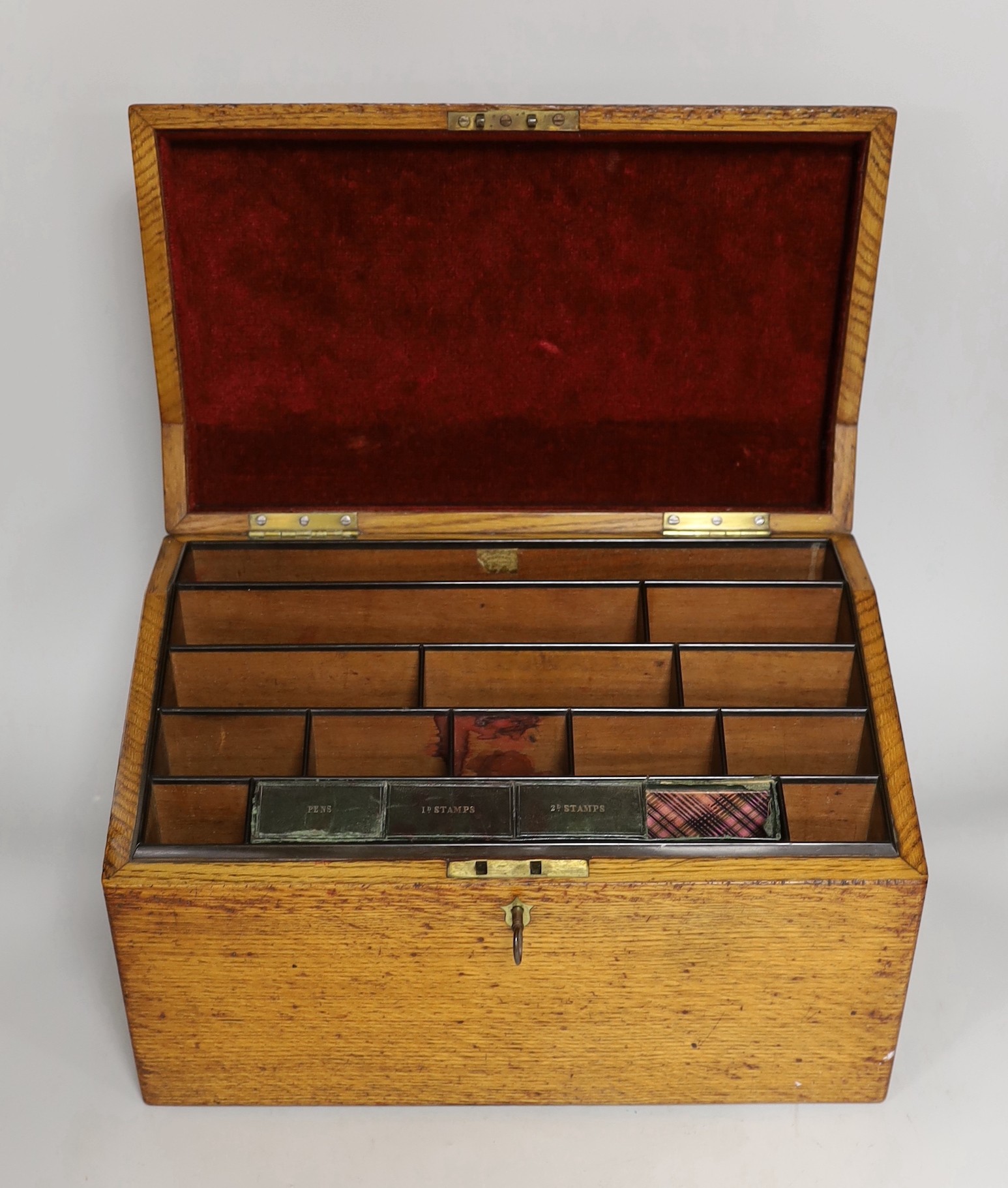 A 19th century oak stationery casket, with a sectional fitted interior and leather compartment for pens, 1d stamps and 2d stamps, 36.5cms wide x 24cms high
